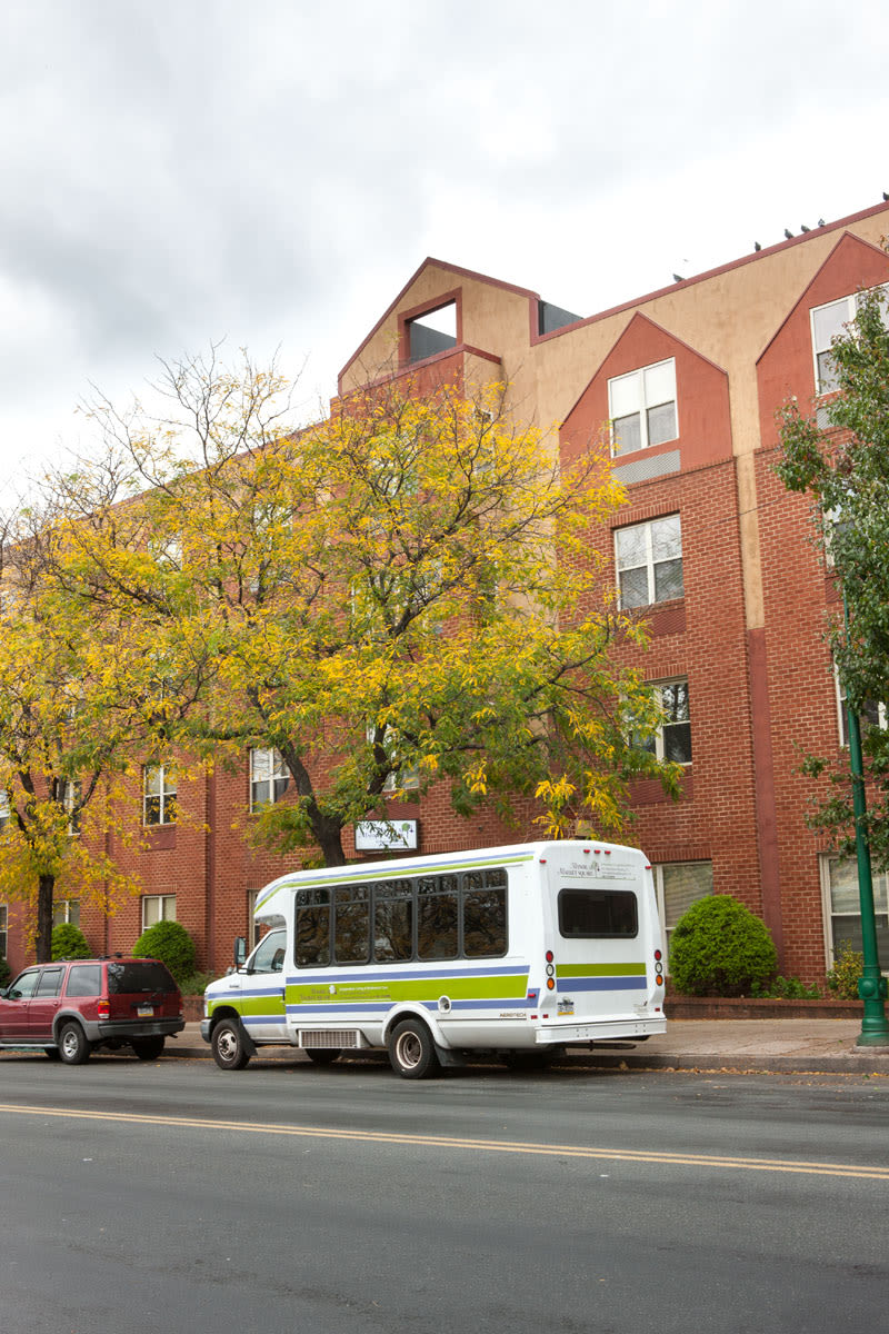Shuttle bus parked outside brick apartment building