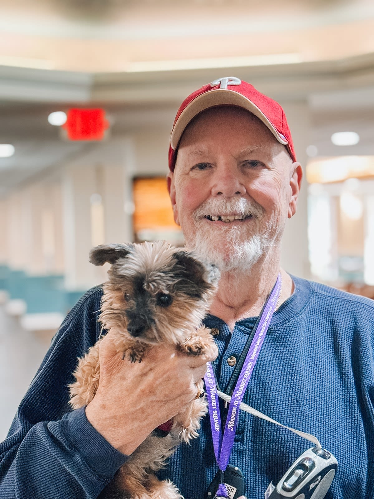 Smiling man holding small dog indoors