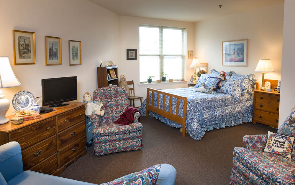 Cozy bedroom with blue floral bedding and wooden furniture